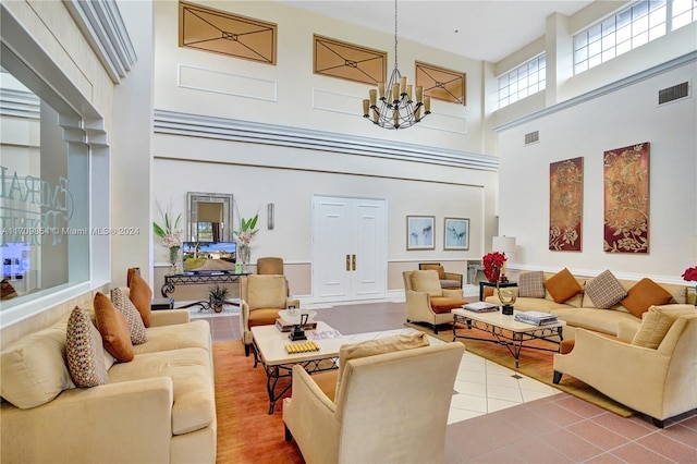 living room featuring hardwood / wood-style floors, a towering ceiling, and an inviting chandelier