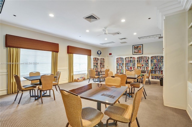 carpeted dining area featuring ceiling fan and ornamental molding