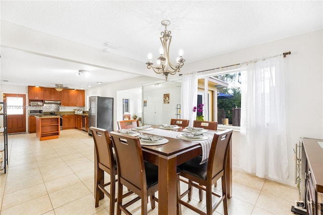 dining room featuring a notable chandelier and light tile patterned flooring