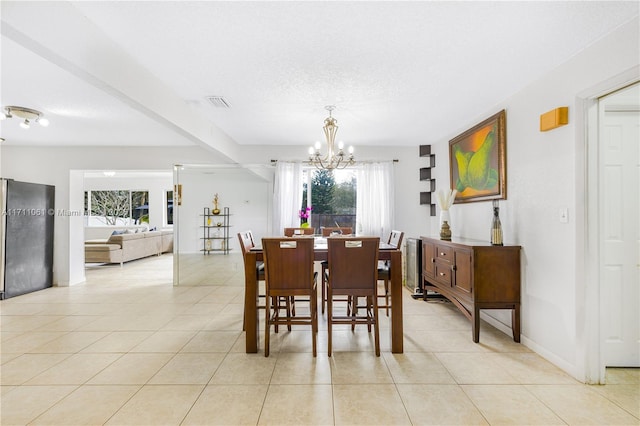 tiled dining area with a textured ceiling and a notable chandelier