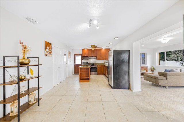 kitchen with light tile patterned flooring, ceiling fan, and stainless steel appliances