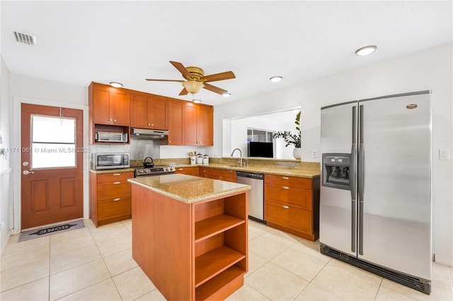 kitchen featuring a kitchen island, appliances with stainless steel finishes, sink, and light tile patterned floors