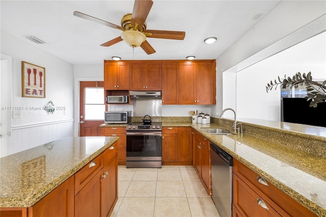 kitchen featuring extractor fan, appliances with stainless steel finishes, light stone countertops, and sink