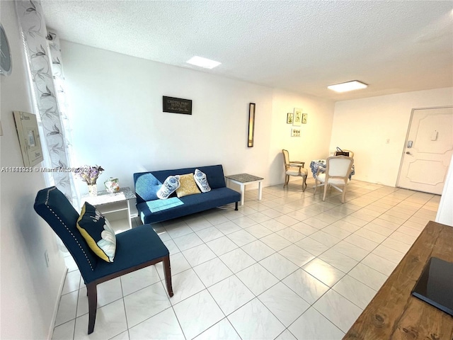 living room featuring light tile patterned floors and a textured ceiling