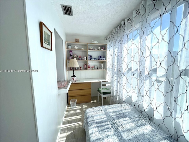 unfurnished bedroom featuring hardwood / wood-style flooring and a textured ceiling