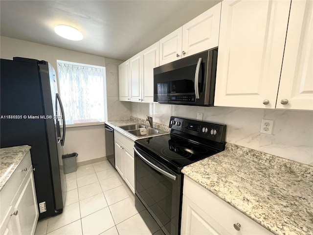 kitchen with sink, light stone countertops, light tile patterned floors, appliances with stainless steel finishes, and white cabinetry