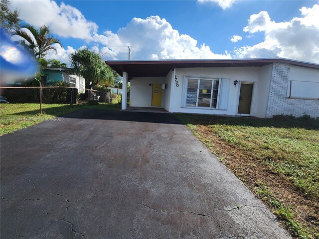 view of front of house featuring a front lawn and a carport