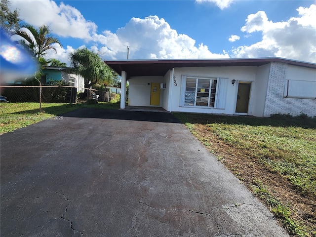 view of front facade featuring a carport and a front lawn