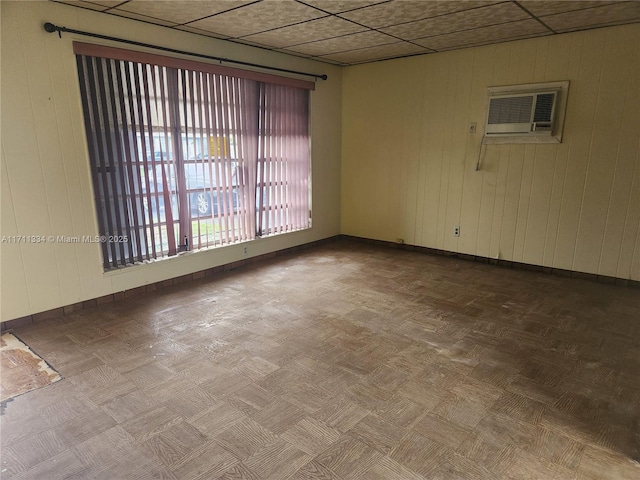 unfurnished room featuring an AC wall unit and parquet floors