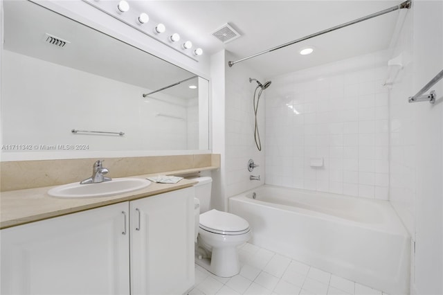 full bathroom with tile patterned flooring, tiled shower / bath combo, toilet, and vanity