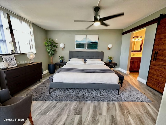 bedroom with ceiling fan, ensuite bathroom, and light hardwood / wood-style floors