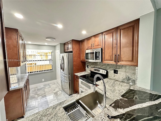 kitchen featuring stainless steel appliances, stone countertops, and backsplash