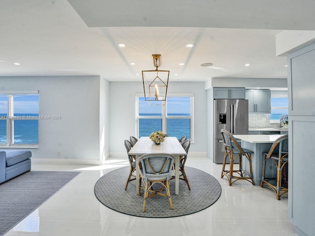 dining space featuring a wealth of natural light, sink, and a water view