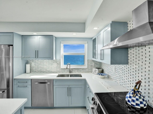 kitchen featuring decorative backsplash, wall chimney exhaust hood, stainless steel appliances, sink, and light tile patterned flooring