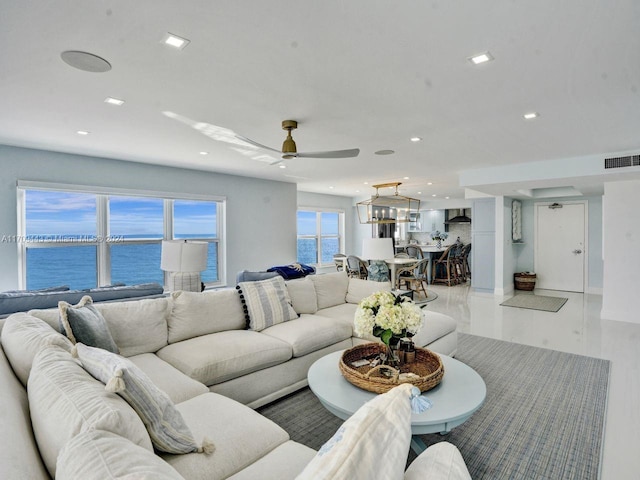 living room with a water view and ceiling fan