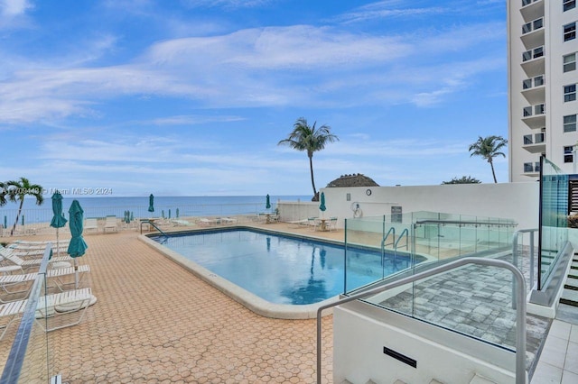 view of pool with a water view and a patio area