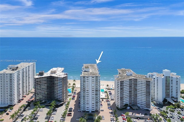 birds eye view of property with a water view and a beach view