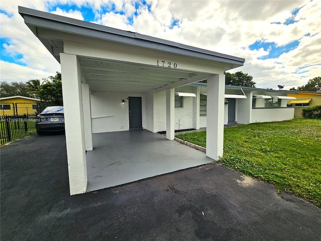 view of parking / parking lot with a yard and a carport