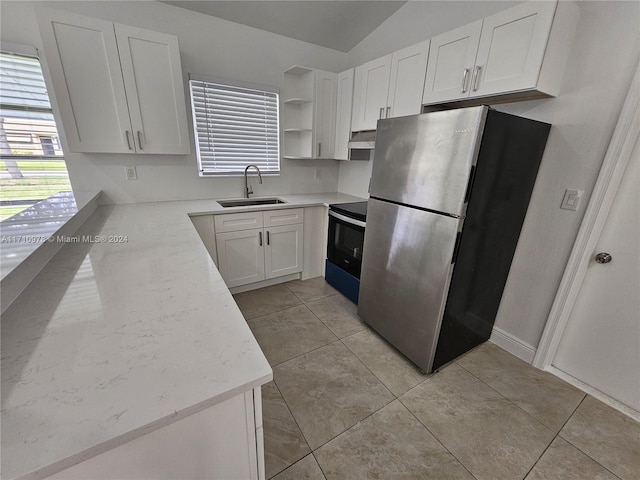 kitchen featuring sink, vaulted ceiling, light tile patterned flooring, white cabinetry, and stainless steel appliances