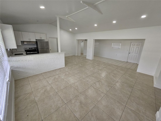 kitchen featuring white cabinetry, stainless steel appliances, kitchen peninsula, vaulted ceiling, and light tile patterned floors