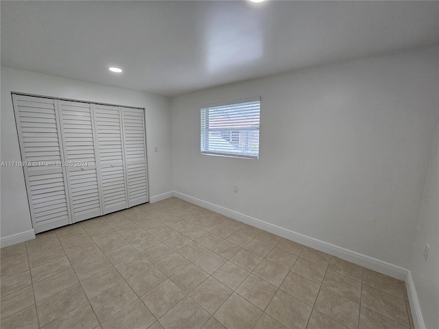 unfurnished bedroom featuring light tile patterned floors and a closet