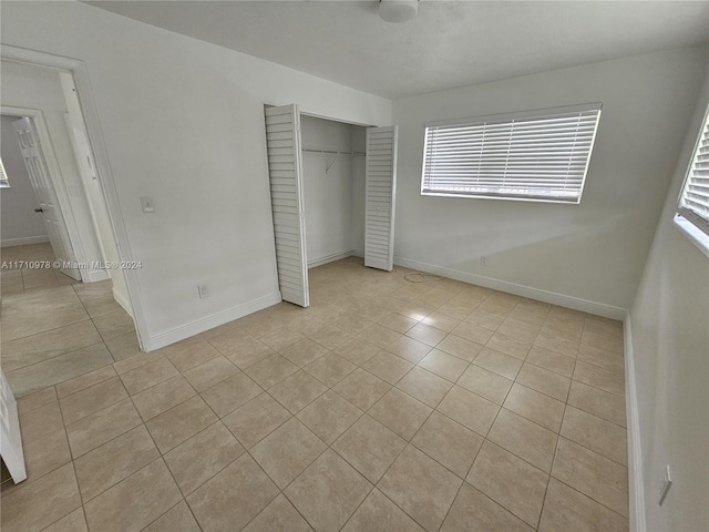 unfurnished bedroom with light tile patterned floors and a closet