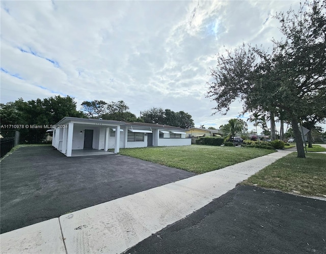 view of front facade featuring a front lawn and a carport