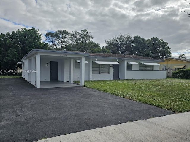 view of front of house with a front yard and a carport