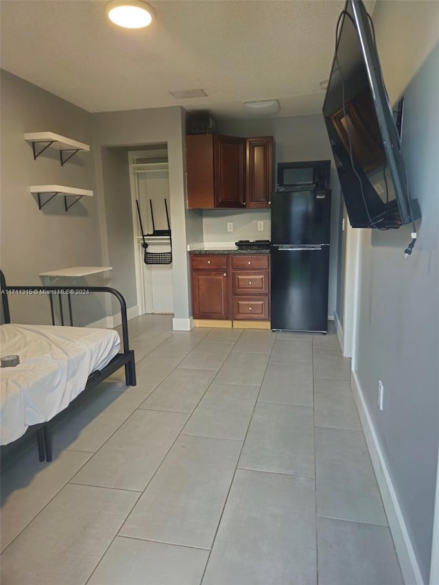 kitchen with light tile patterned floors and black appliances