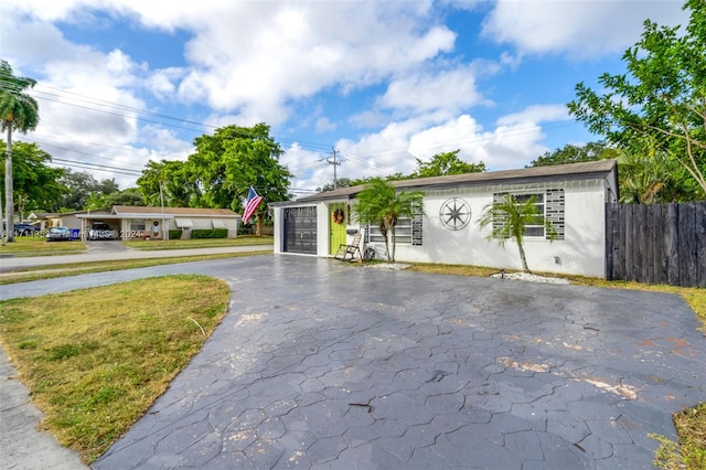 ranch-style house featuring a garage and a front lawn