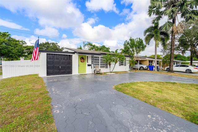 single story home featuring a garage and a front lawn