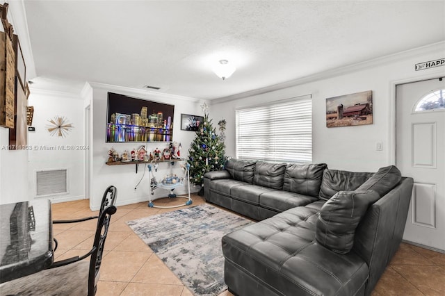 living room featuring a textured ceiling, light tile patterned floors, and crown molding