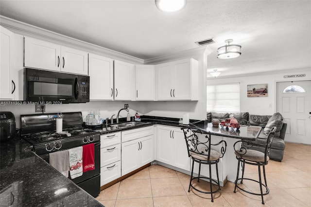 kitchen with black appliances, white cabinets, sink, and dark stone counters