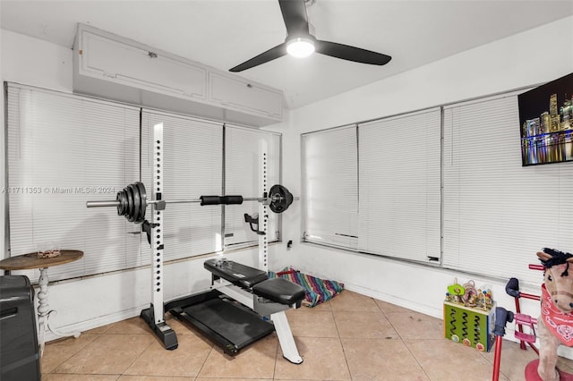 exercise area featuring ceiling fan and light tile patterned floors