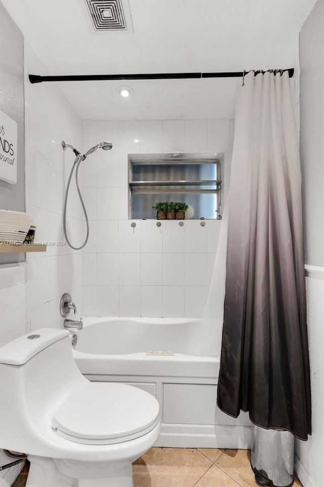 bathroom with tile patterned floors, shower / bath combination with curtain, and toilet