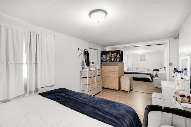 bedroom with light hardwood / wood-style flooring and a closet