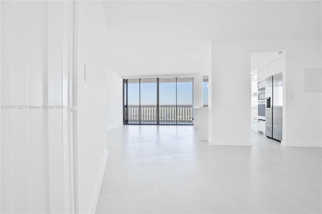 unfurnished living room featuring light tile patterned floors and floor to ceiling windows