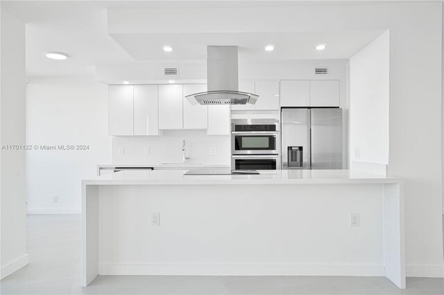 kitchen featuring white cabinets, sink, island exhaust hood, and appliances with stainless steel finishes