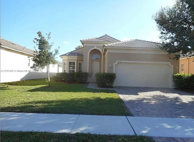 mediterranean / spanish-style home with a front yard and a garage