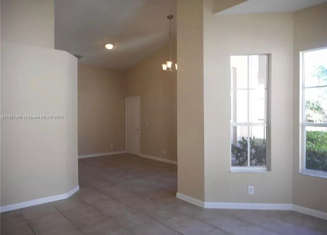 empty room with a notable chandelier and vaulted ceiling