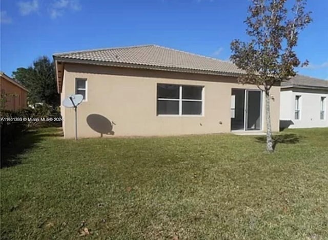 back of house featuring a lawn