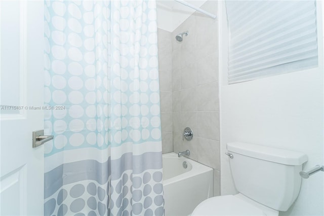 bathroom with shower / bath combination with curtain and toilet