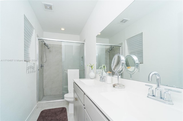 bathroom featuring tile patterned floors, vanity, toilet, and a shower with shower door