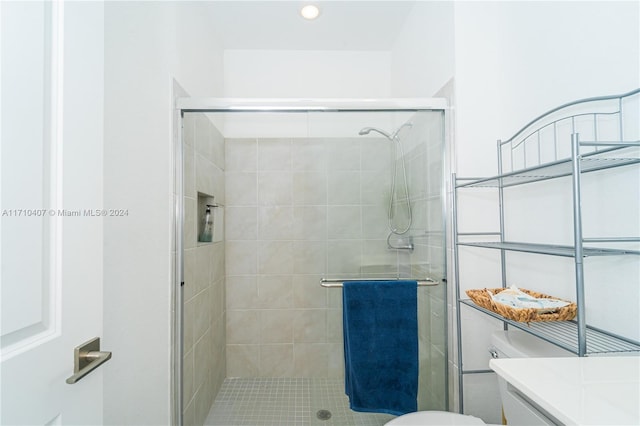 bathroom with toilet, an enclosed shower, and vanity