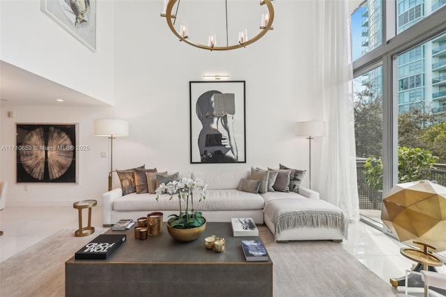 tiled living room featuring a towering ceiling and a chandelier