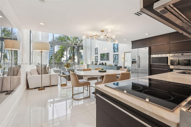 kitchen with dark brown cabinetry, a wall of windows, stainless steel refrigerator with ice dispenser, black electric stovetop, and light tile patterned flooring