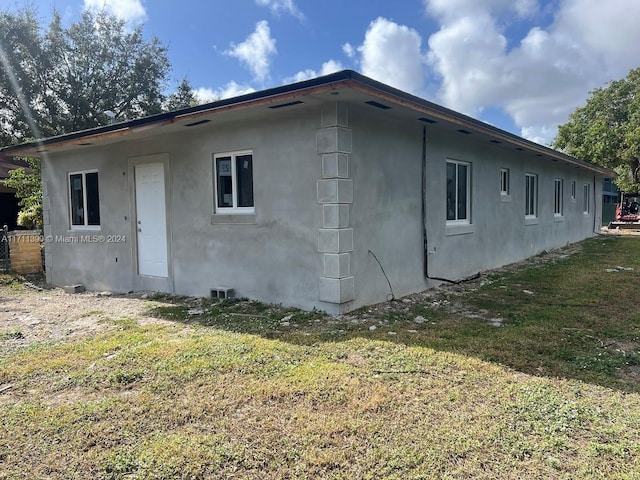 back of house with a lawn