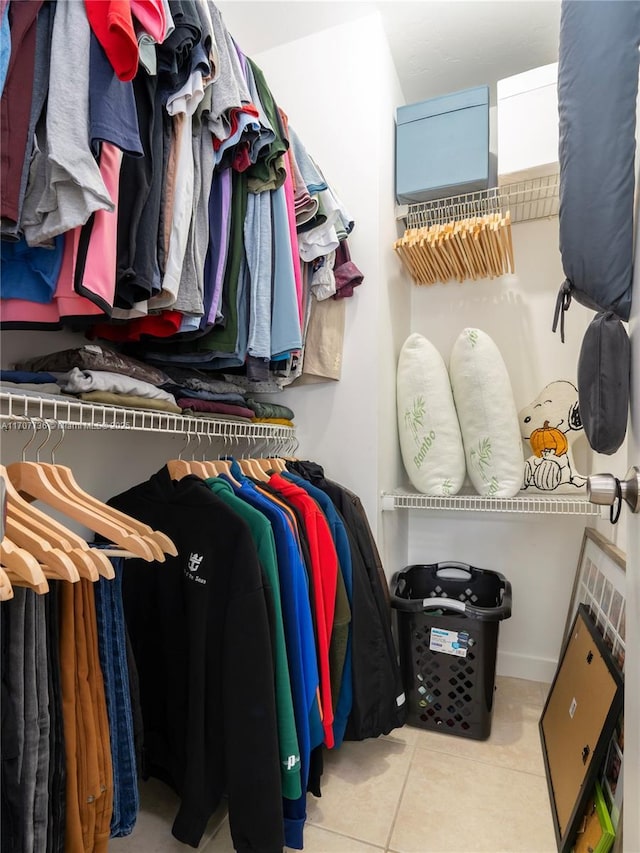 walk in closet with light tile patterned floors