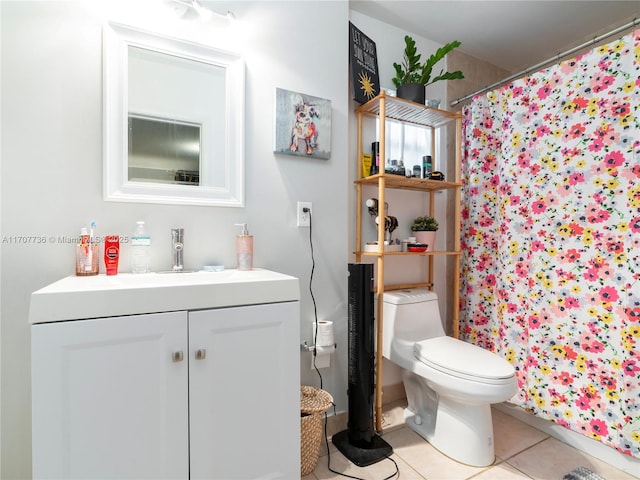 bathroom featuring tile patterned flooring, vanity, toilet, and walk in shower