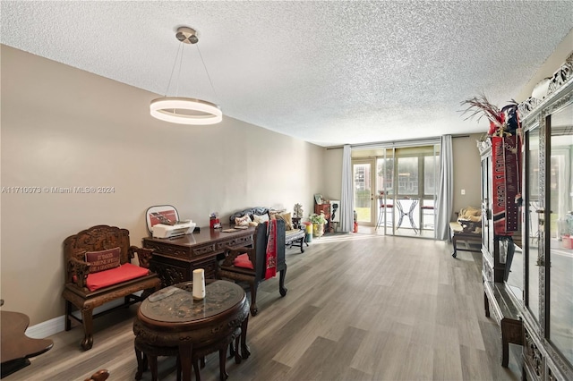 dining space featuring hardwood / wood-style flooring, expansive windows, and a textured ceiling